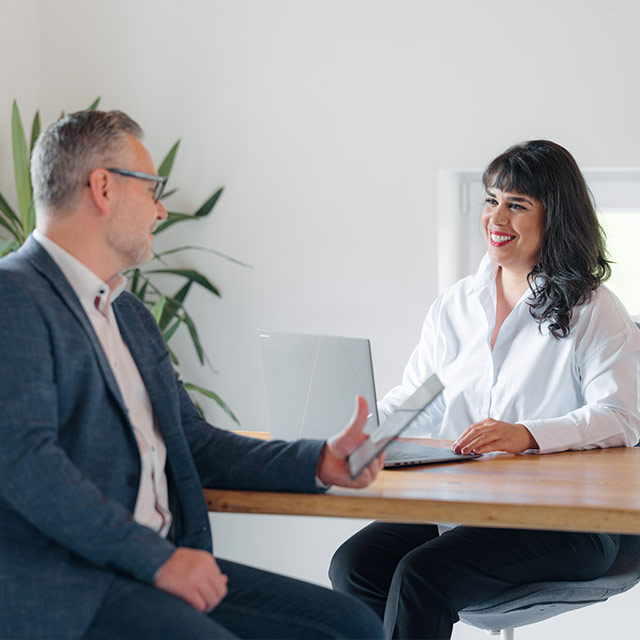 Monique Senicky im Gespräch mit Lukas Senicky über individuelle Versicherungslösungen – persönliche und unabhängige Beratung bei GT Capital im modernen Büro.